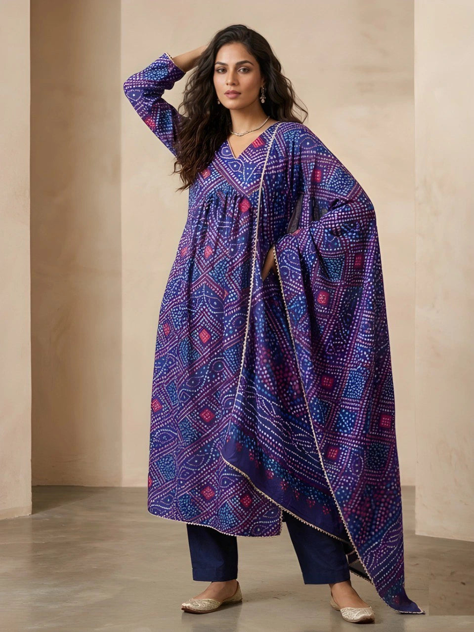 Woman wearing a blue patterned kurta with a matching dupatta against a beige background